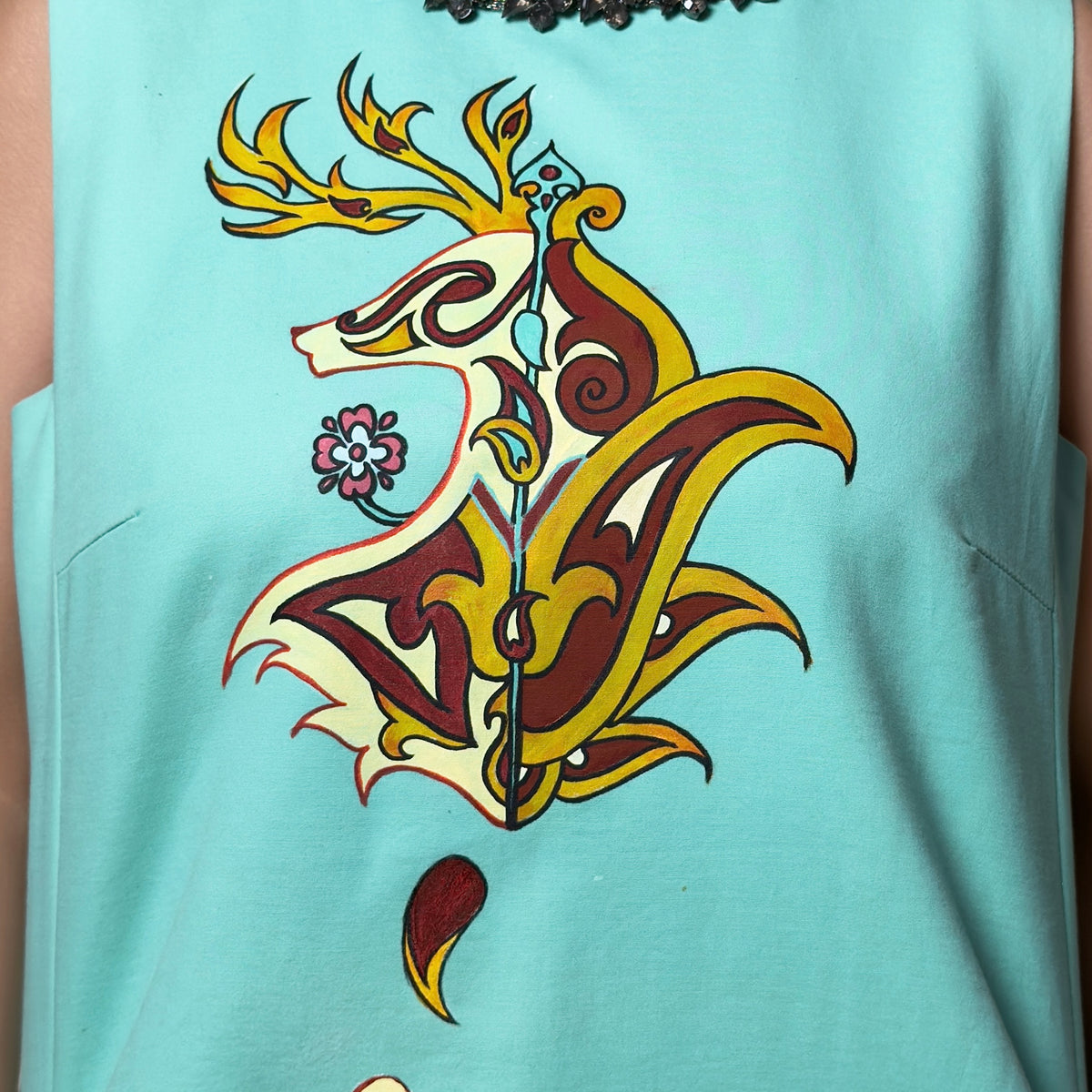 Close-up of the hand-painted stag motif on the Fireborne Stag turquoise dress by HANDLURIA.