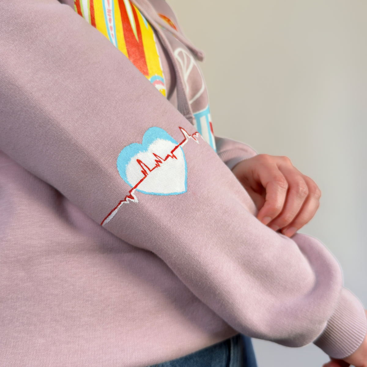 Close-up of the hand-painted blue and white heart with a red zigzag line on the sleeve of Northern Bird Song | Painted by HANDLURIA.