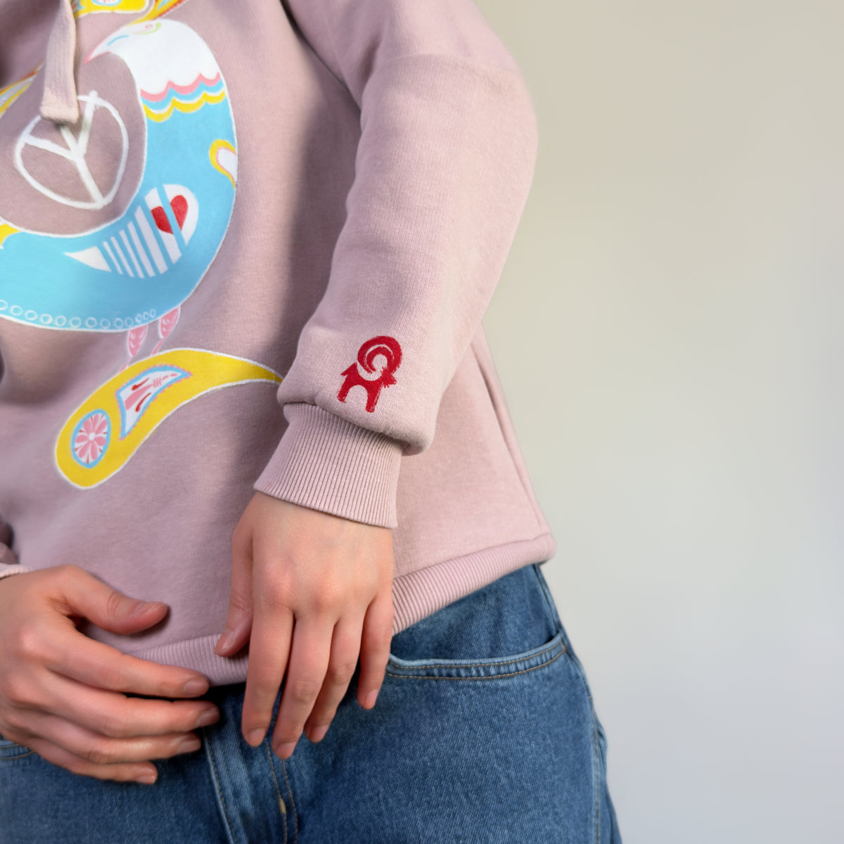 Detail view of Northern Bird Song | Painted by HANDLURIA, showing the red emblem above the ribbed sleeve cuff.
