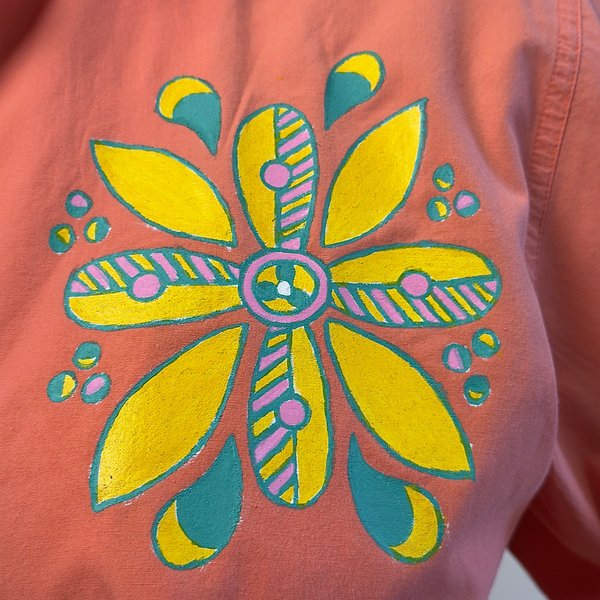 Close-up of the hand-painted yellow, teal and pink flower motif on Songbird Bloom by HANDLURIA.