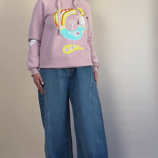 Northern Bird Song | Painted hand-painted blush-pink hoodie by HANDLURIA worn in motion.